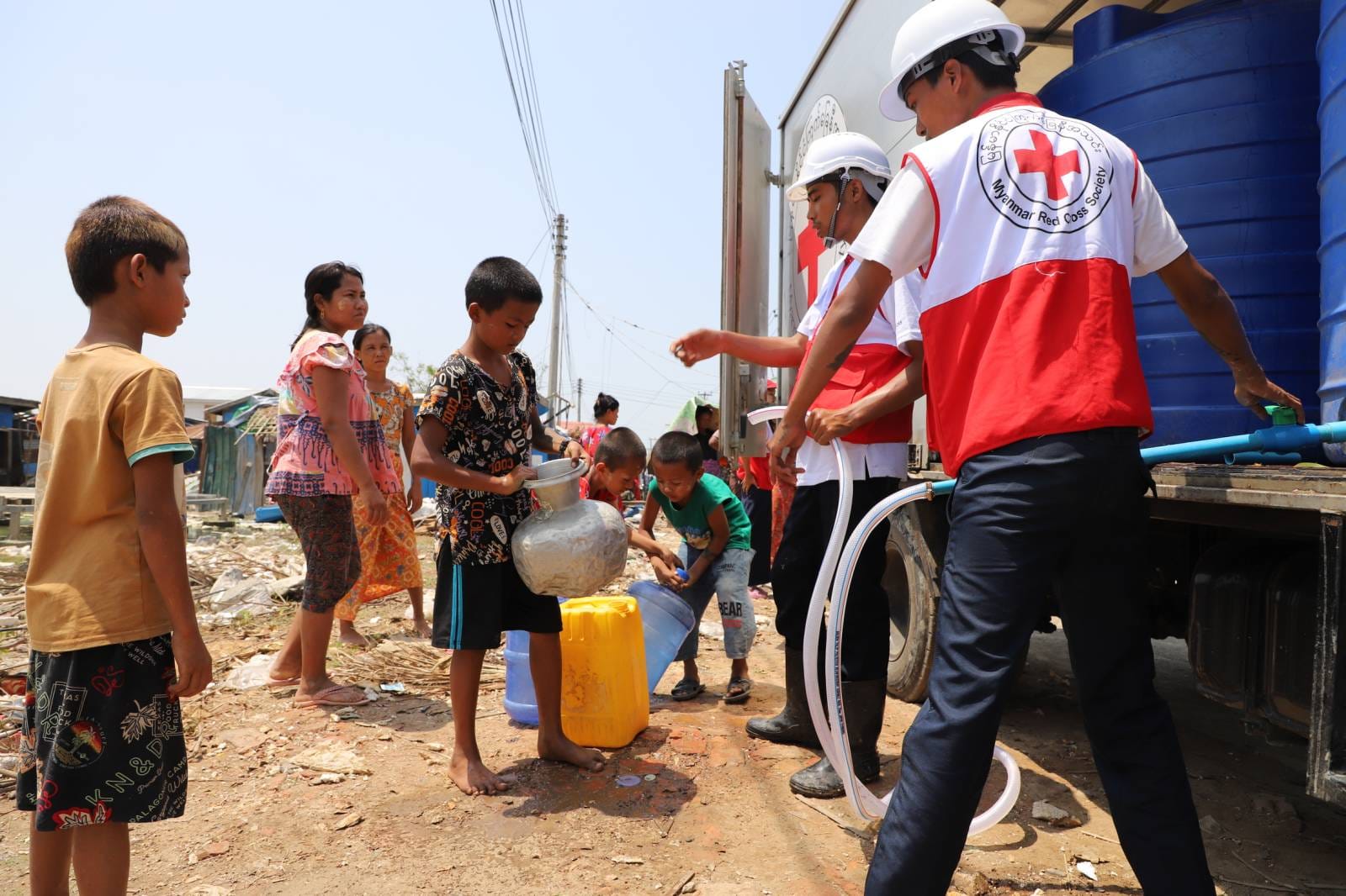 Myanmar Red Cross volunteers provide drinking water to children in communities affected by Cyclone Mocha